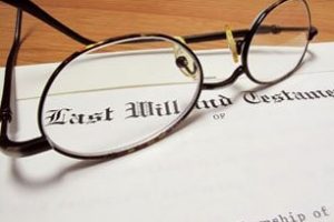 A pair of eyeglasses resting on a document titled "Last Will and Testament.